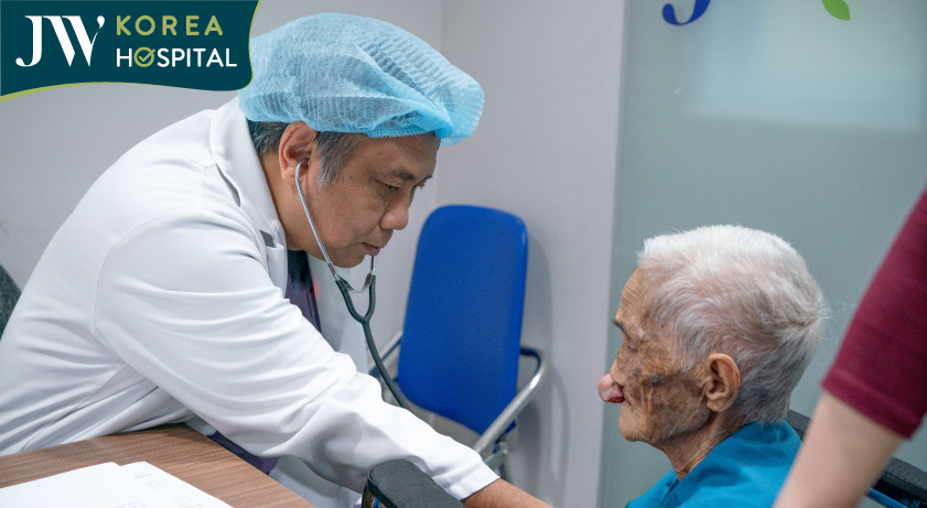 Cụ bà 100 tuổi đang được bác sĩ JW kiểm tra sức khỏe trước khi thực hiện phẫu thuật cắt bỏ khối u mạch máu chèn ép ở mũi 