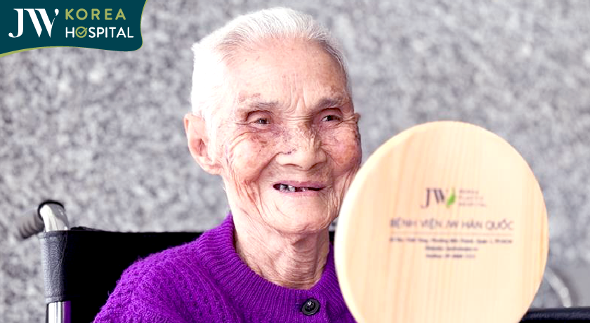 Cụ Lê Thị Khoan cười tươi khi nhìn thấy hình ảnh của mình trong gương sau ca phẫu thuật cắt khối u mạch máu